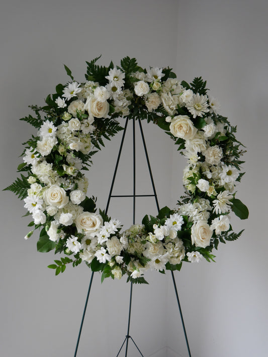 funeral floral wreath featuring hydrangeas, roses, spray roses, chrysanthemum, carnations and more 