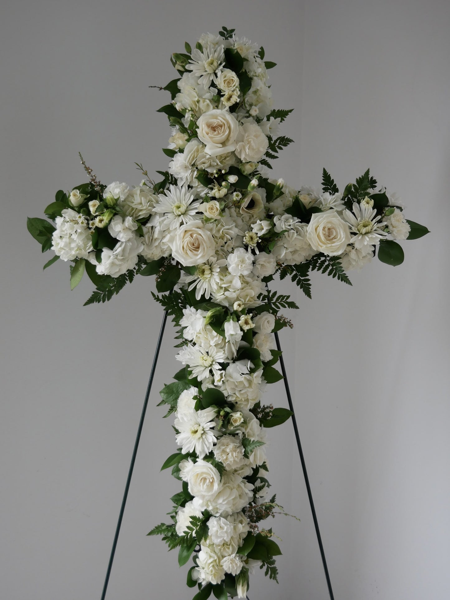 Stranding flower cross in white color pallet featuring hydrangea, roses, chrysanthemum and more