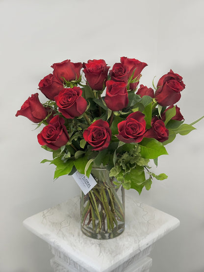 2 dozen red roses with greenery  in clear cylinder