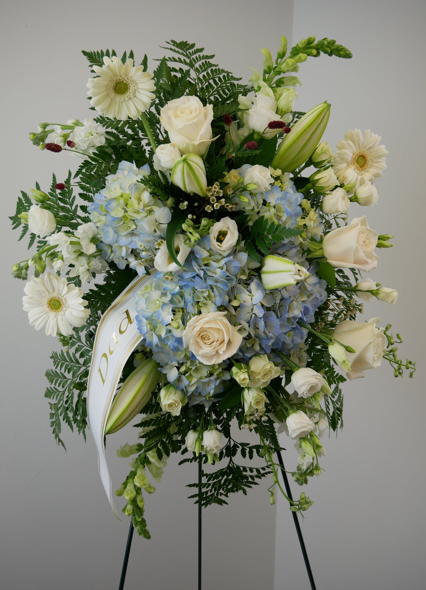 Funeral white and blue spray featuring hydrangea, roses, gerberas, lilies and other