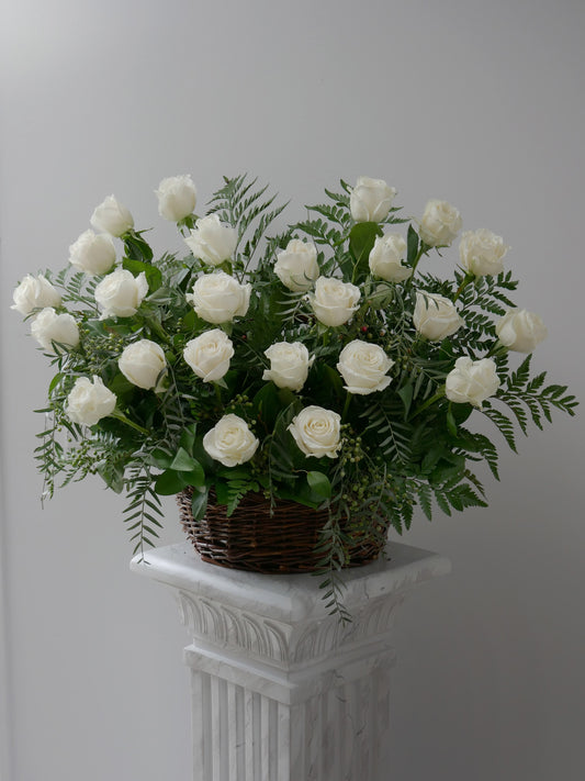 Elegant flower basket featuring 2 dozen white roses and premium foliage