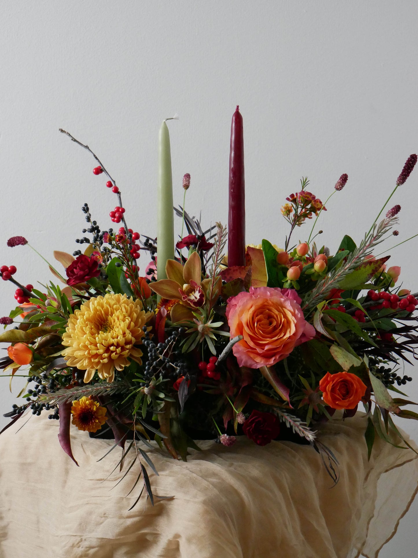 Fall floral centerpiece with candles on a neutral background