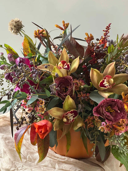 Close up on Blooming Pumpkin Thanksgiving floral arrangement with cymbidium orchids and lisianthus by Floral Esthetics