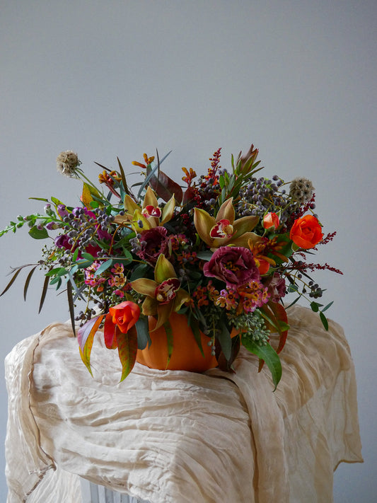 Blooming Pumpkin Thanksgiving floral arrangement with cymbidium orchids and lisianthus by Floral Esthetics