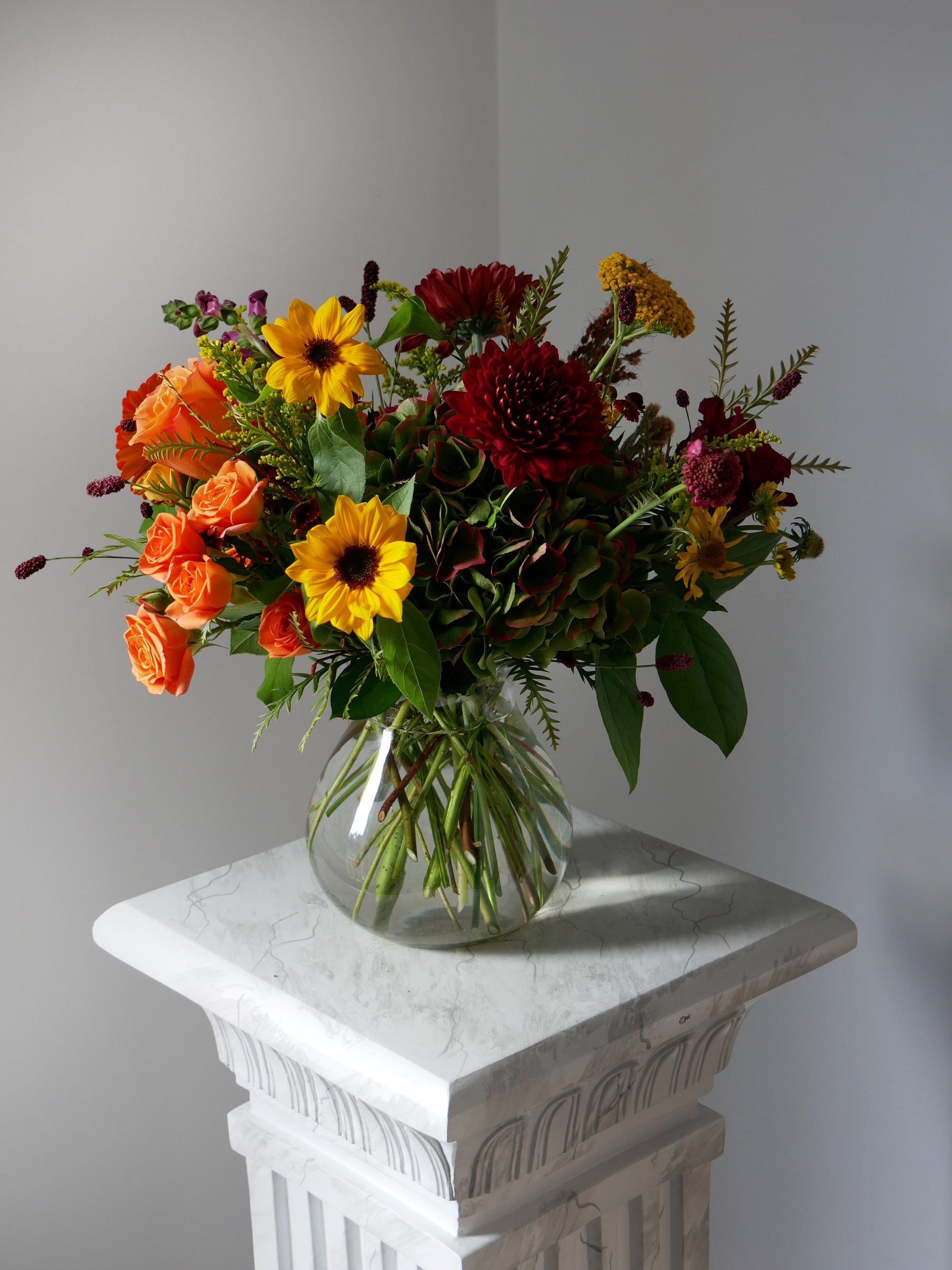 Standard size fall arrangement in vase featuring little sunflowers, spray roses, chrysanthemum, hydrangeas, seasonal blooms and berries by Floral Esthetics