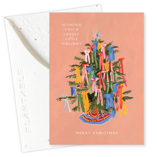 Christmas card with a decorated tree and colorful ribbons on a pink background