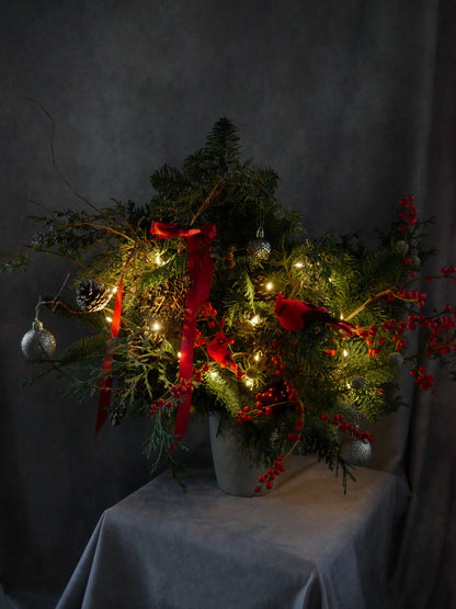 Christmas Magic arrangement featuring noble fir, Incense cedar, pine tree, Ilex berries, pine cones and matching color toys. By Floral Esthetics