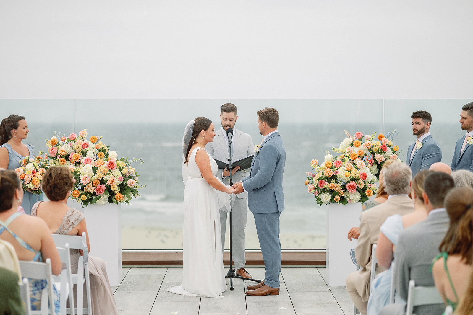 Colorful Cape Cod wedding ceremony arrangements on modern white pedestals 