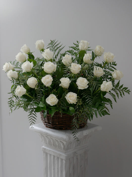 Elegant flower basket featuring 2 dozen white roses and premium foliage by Floral Esthetics