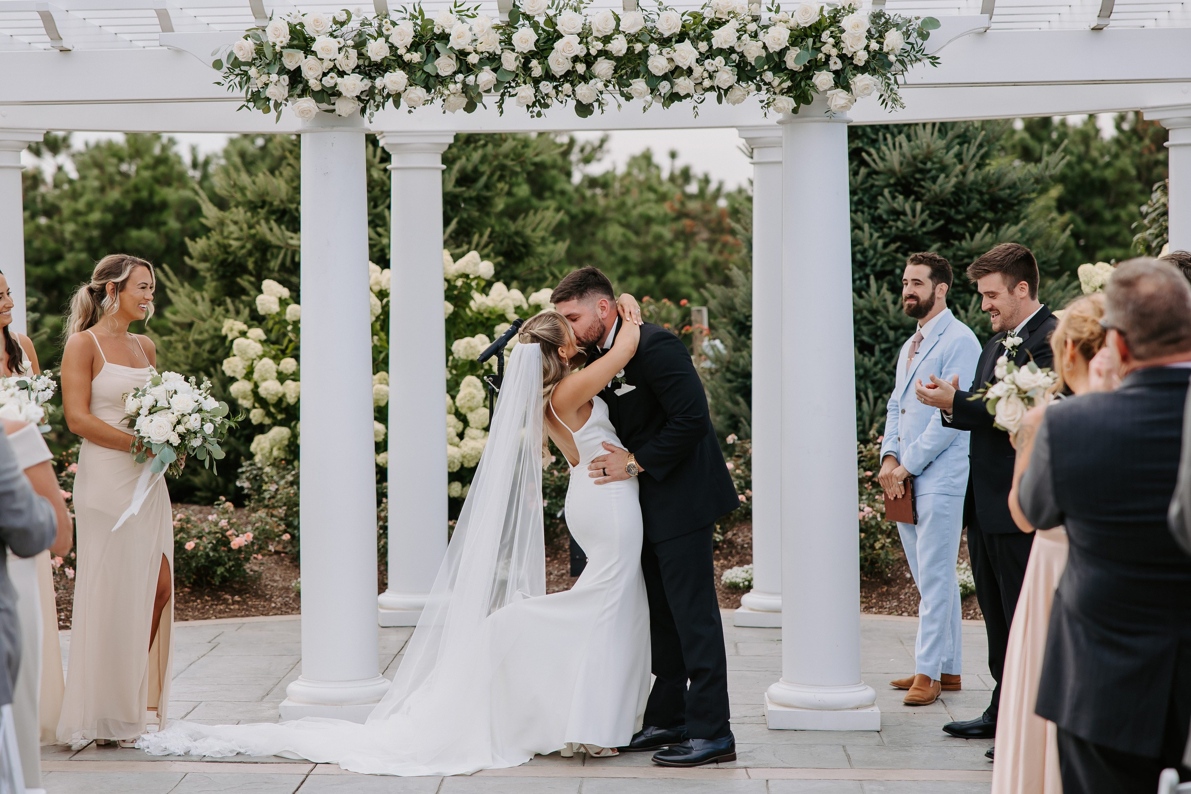 Elegant wedding ceremony by Floral Esthetics featuring white flowers: roses, spray roses, lisianthus, eucalyptus and other greenery 