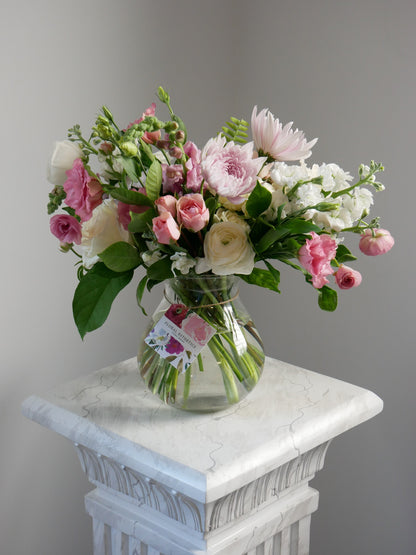 Pink and white standard size flower arrangement in clear vase featuring ranunculus, chrysanthemum, roses and more by Floral Esthetics