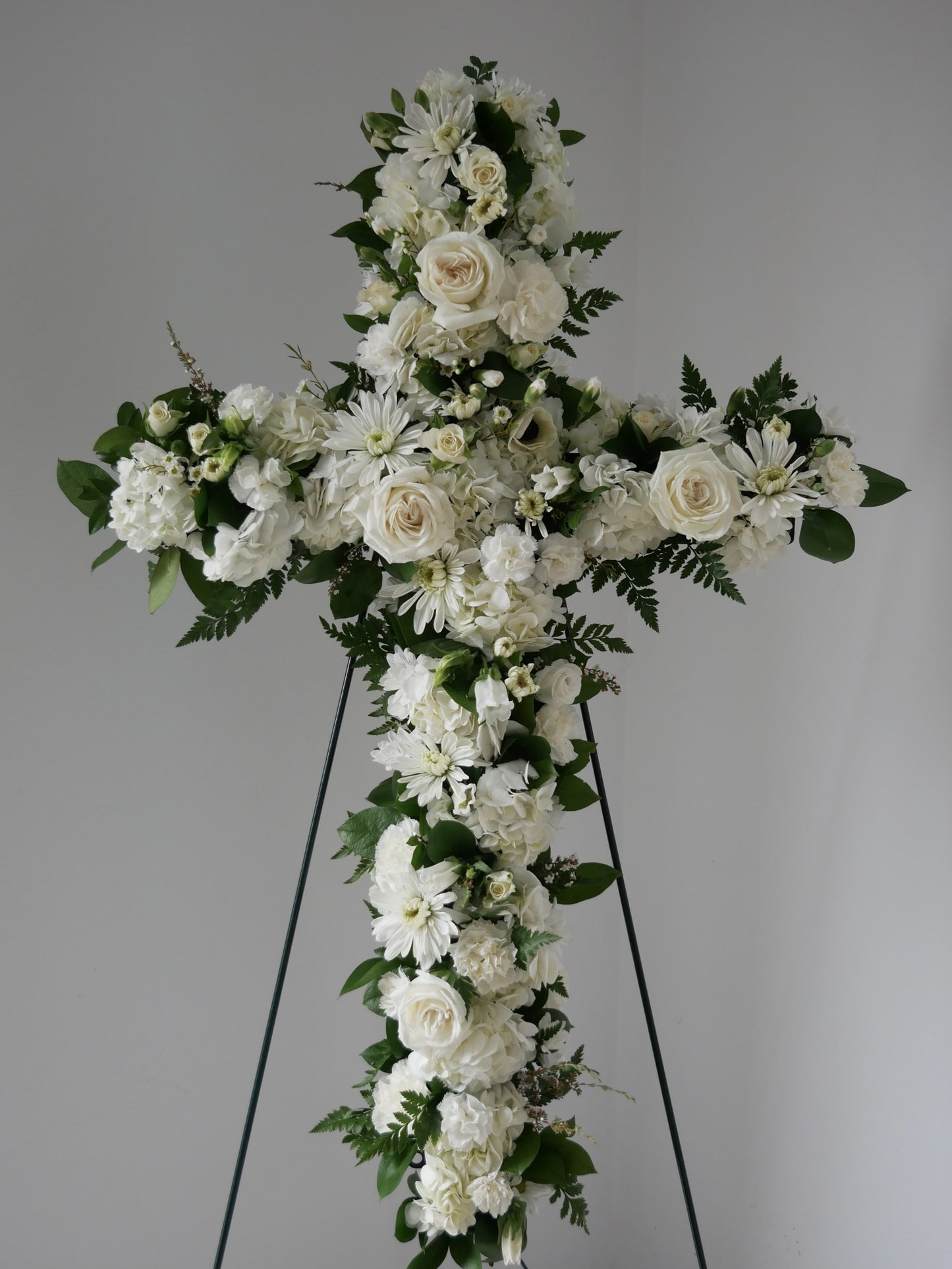 Stranding flower cross in white color pallet featuring hydrangea, roses, chrysanthemum and more by Floral Esthetics