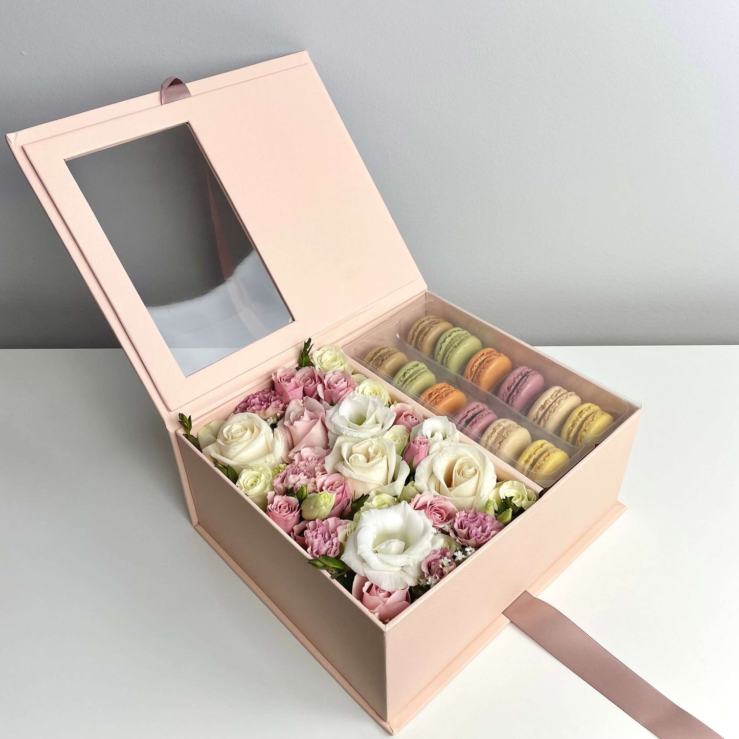 Pink flower box with macarons featuring white and pink roses