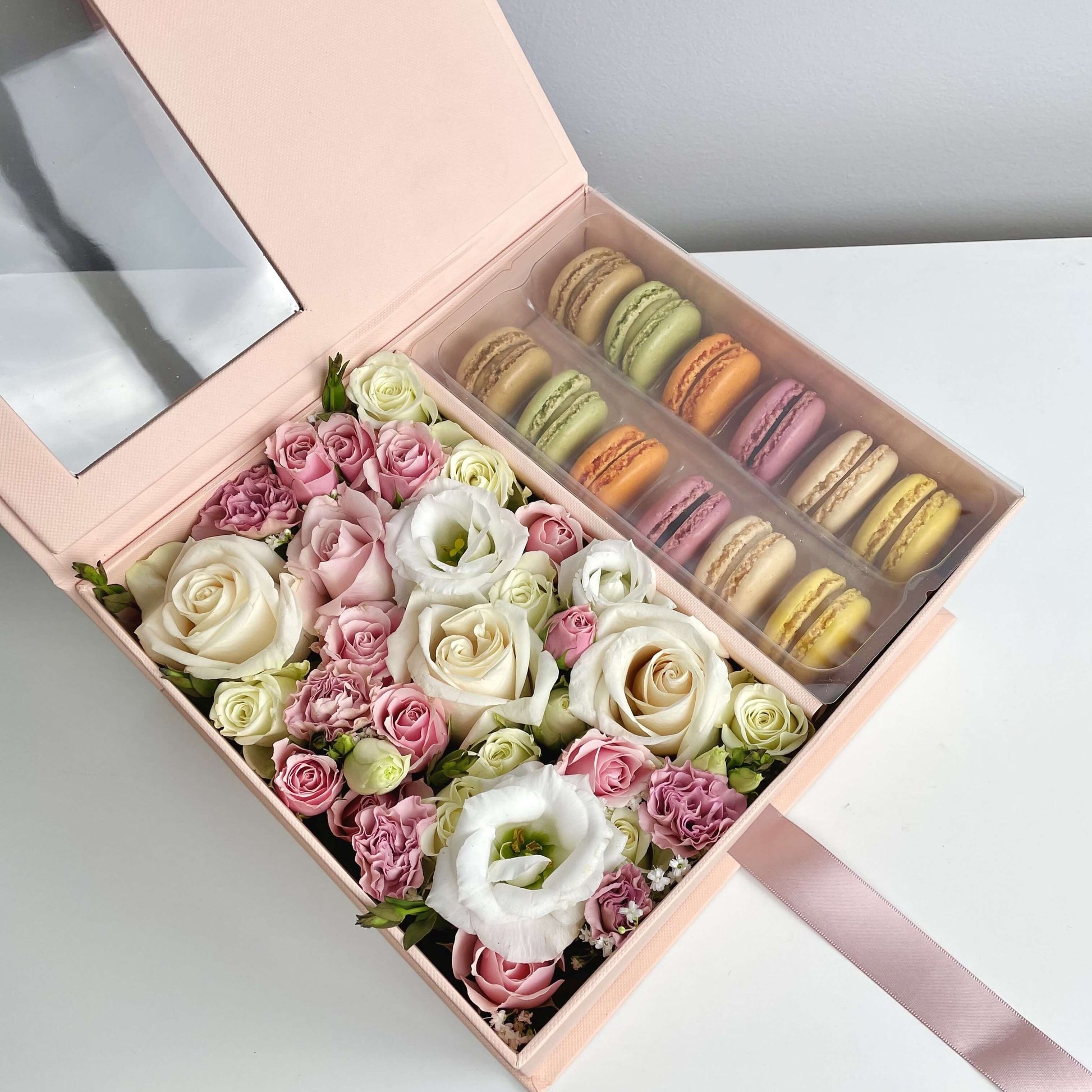 Close-up on Pink flower box with macarons featuring white and pink roses