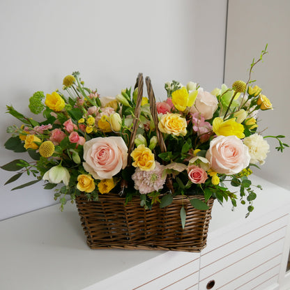 Spring large size flower basket featuring tender pink roses, yellow spray roses, daffodils, tulips, hellebore and more