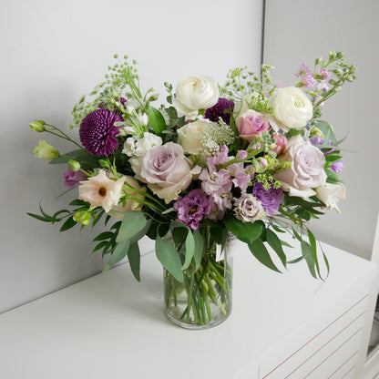 Luxury white and purple flower arrangement featuring ranunculus, roses, lisianthhus and eucalyptus 