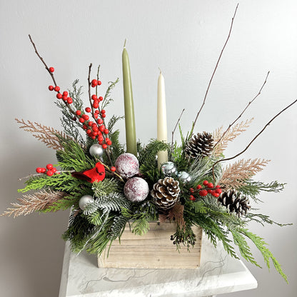 Long lasting Christmas Arrangement in wooden box with candles featuring noble fir, Incense cedar, pine tree, Ilex berries, pine cones and matching color toys. By Floral Esthetics