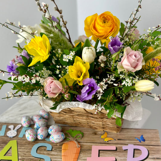 spring flower basket featuring daffodils, tulips, roses, ranunculus, pussy willow and other spring branches and greenery